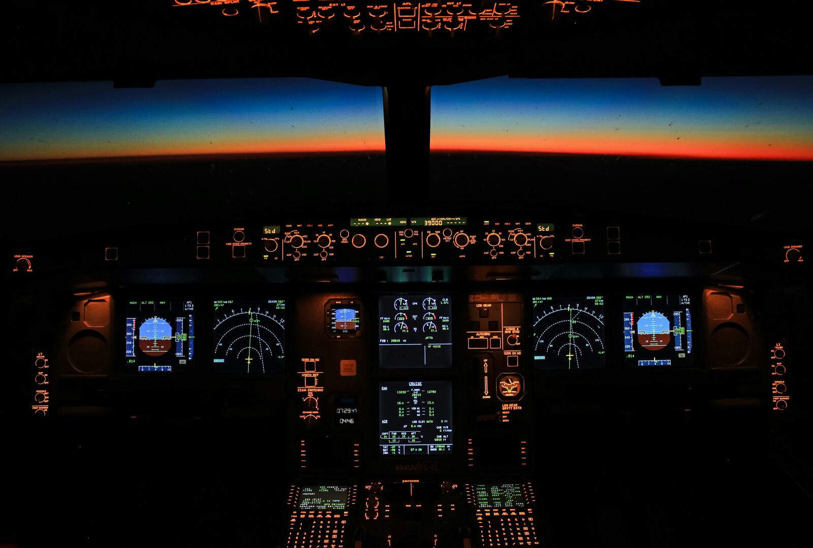 Commercial aircraft cockpit at dawn, instruments illuminated
